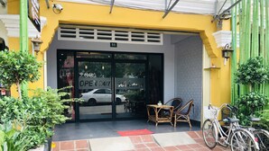 A building entrance with a sign indicating it's open 24/7. - Maison Rivera Guest House (Kampot)