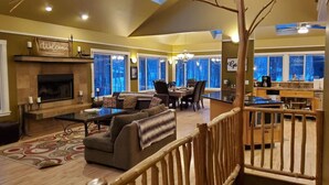 A spacious living room with a fireplace, a dining area, and a kitchen.