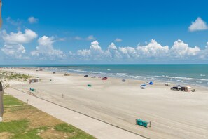 A wide beach with a clear sky and calm sea. - Luxury Beachfront Condo | Stunning Gulf Views (Corpus Christi)