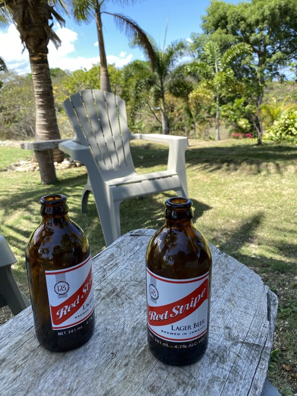 Two bottles of Red Stripe beer on a wooden table outdoors. - Panoramic views with room to roam in a relaxing environment. (Haughton Court)