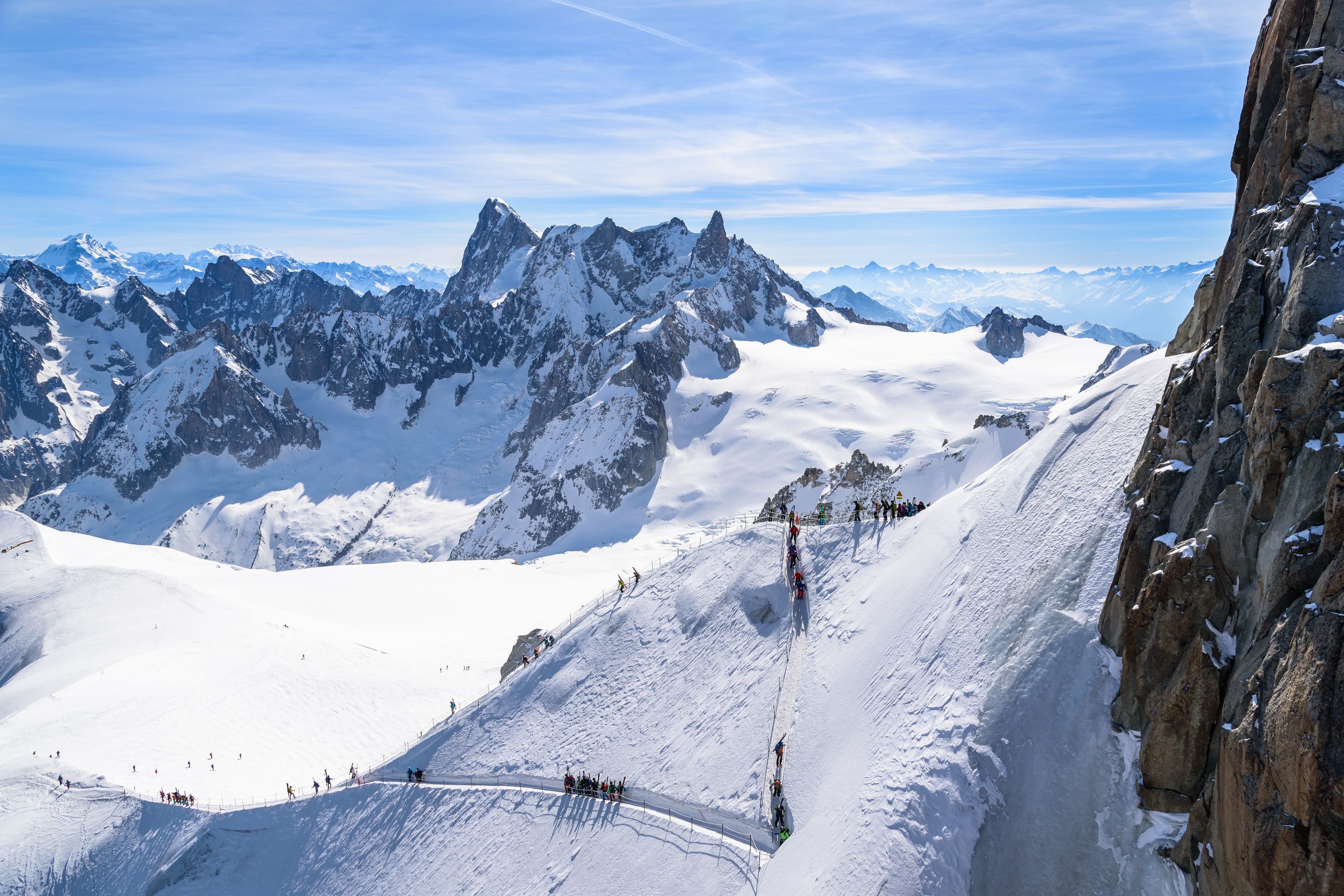 Un paysage montagneux enneigé, avec des affleurements rocheux et un ciel dégagé.