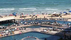 Un complexe hôtelier doté de plusieurs piscines, d’une plage et de transats.