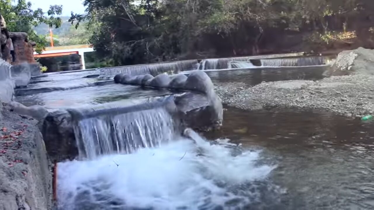 Un élément décoratif aquatique composé de plusieurs cascades et d’une structure en pierre.