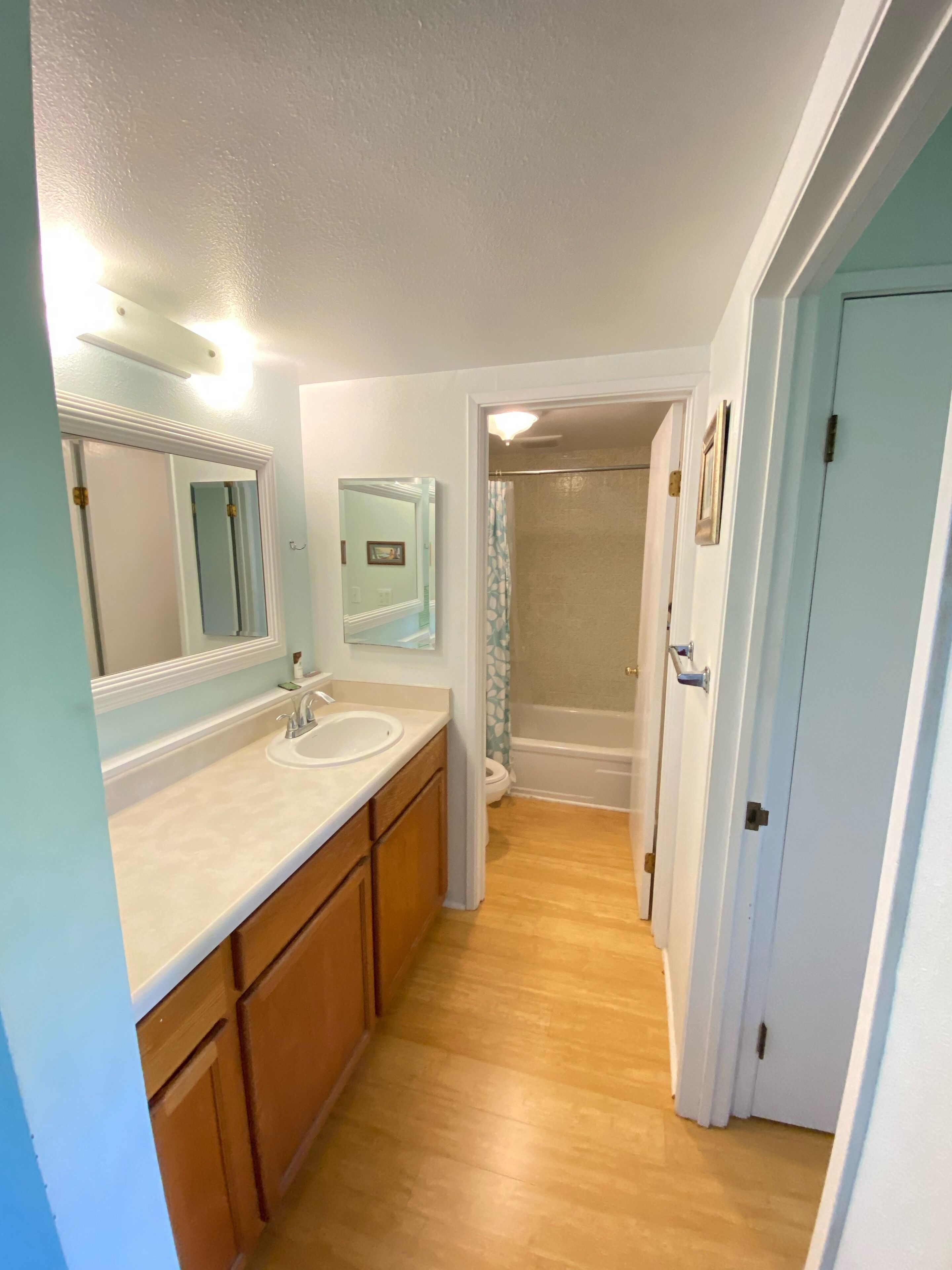Une salle de bain avec un double lavabo, des meubles en bois, un miroir et un espace douche.