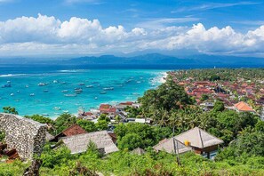 A coastal town with a view of the ocean and mountains in the distance. - Kayu Manis Guest House Lembongan (Lembongan Island)