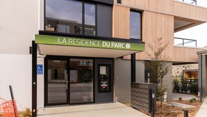Ein modernes Gebäude mit einem Schild, auf dem „LA RESIDENCE DU PARC“ steht.