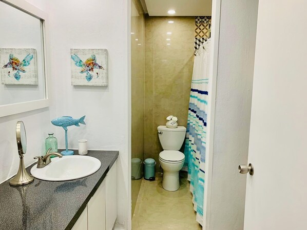 A bathroom with a sink, mirror, and two wall-mounted artwork pieces. - Casa Bliss (Carolina)