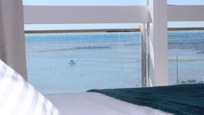 Una habitación con un ventanal grande con vistas a la playa.