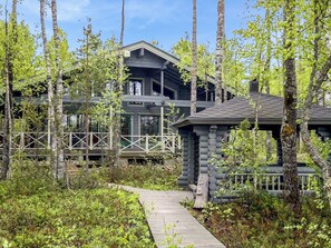 A cabin with a wooden deck, surrounded by trees. - Villa tilia by Interhome (Pertunmaa)