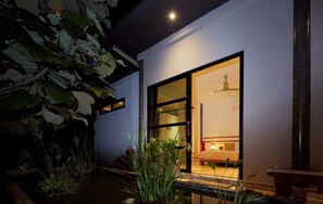 Ein modernes Haus mit einer großen Glasdoor, die zu einem Schlafzimmer führt.