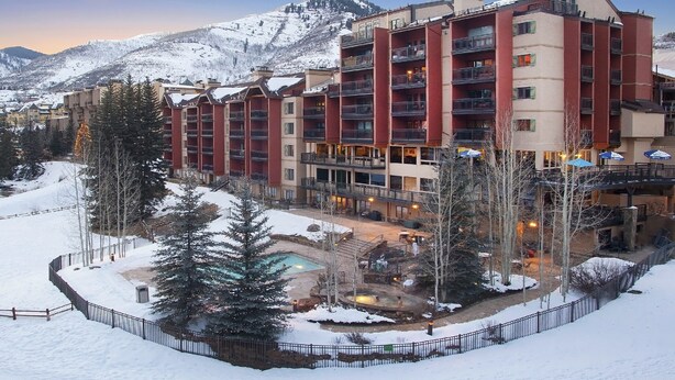 A multi-story hotel with balconies, a pool, and a snowy mountain backdrop. - Ski In and Out Condo in Lionshead Village w/ Pool, Hot Tubs, and Lovely Views (Vail)