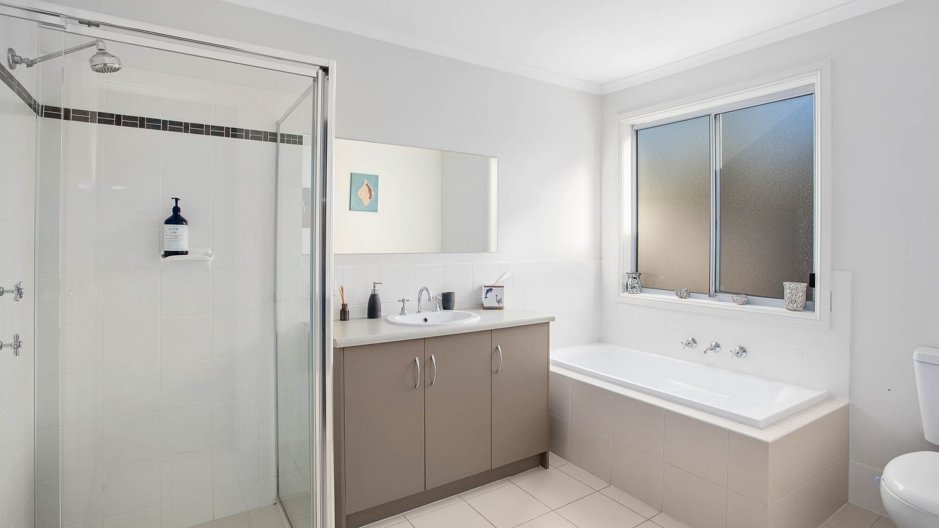 Une salle de bain moderne avec une douche à parois de verre, un grand lavabo et des toilettes.