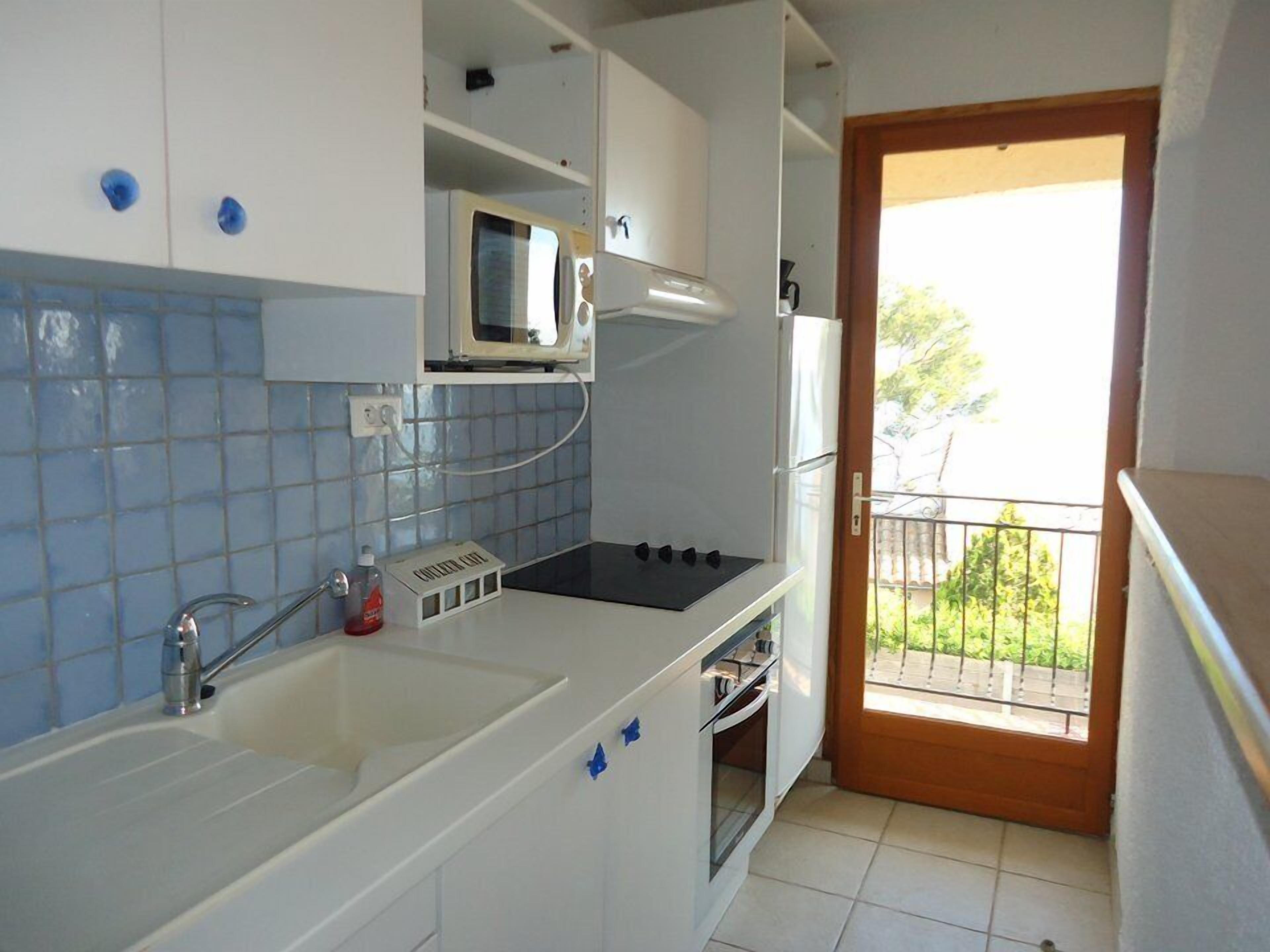 A compact kitchen with a microwave, stove, sink, and oven.