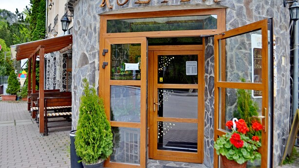 Un edificio de piedra con el nombre "KOLIBA" grabado en la fachada.
