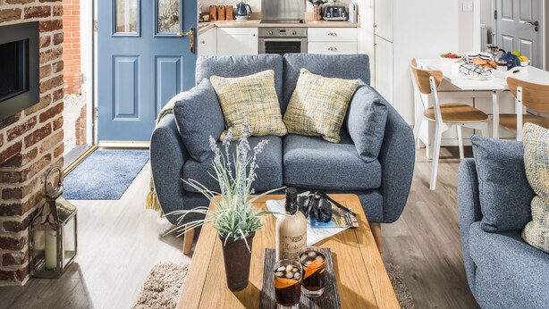 A modern living room with a blue sofa, a coffee table, and a fireplace.