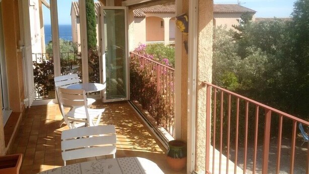 A balcony with a table and chairs, a potted plant, and a view of the sea. - Contemporary apartment with air conditioning in a residence with swimming-pool (CAVALAIRE sur mer)