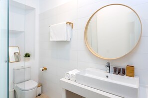 Une salle de bain moderne avec des toilettes, un lavabo et un miroir.