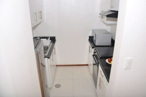 Kitchen features an oven, microwave, and sink with a faucet.