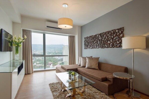 Relax in this stylish living room with a city view, featuring a sofa, coffee table, and flat-screen TV.