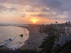 A beach with a sunset, buildings along the shore, and a clear sky. - 6 Blks from beach. Walking distance to restaurants, shops. Excellent location! (Newport Beach)