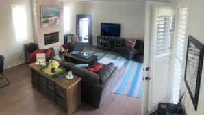 Uma sala de estar com lareira, televisão e sofá.