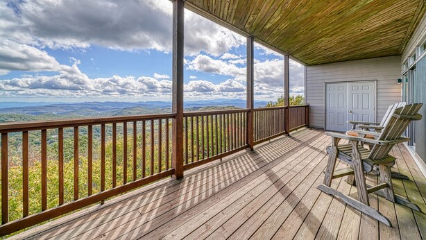 A wooden deck with a view of mountains and a cloudy sky. - Close-to-slopes condo w/gourmet kitchen & stone fireplace (Sugar Mountain)