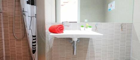 A bathroom with a shower, a sink, and a toilet.