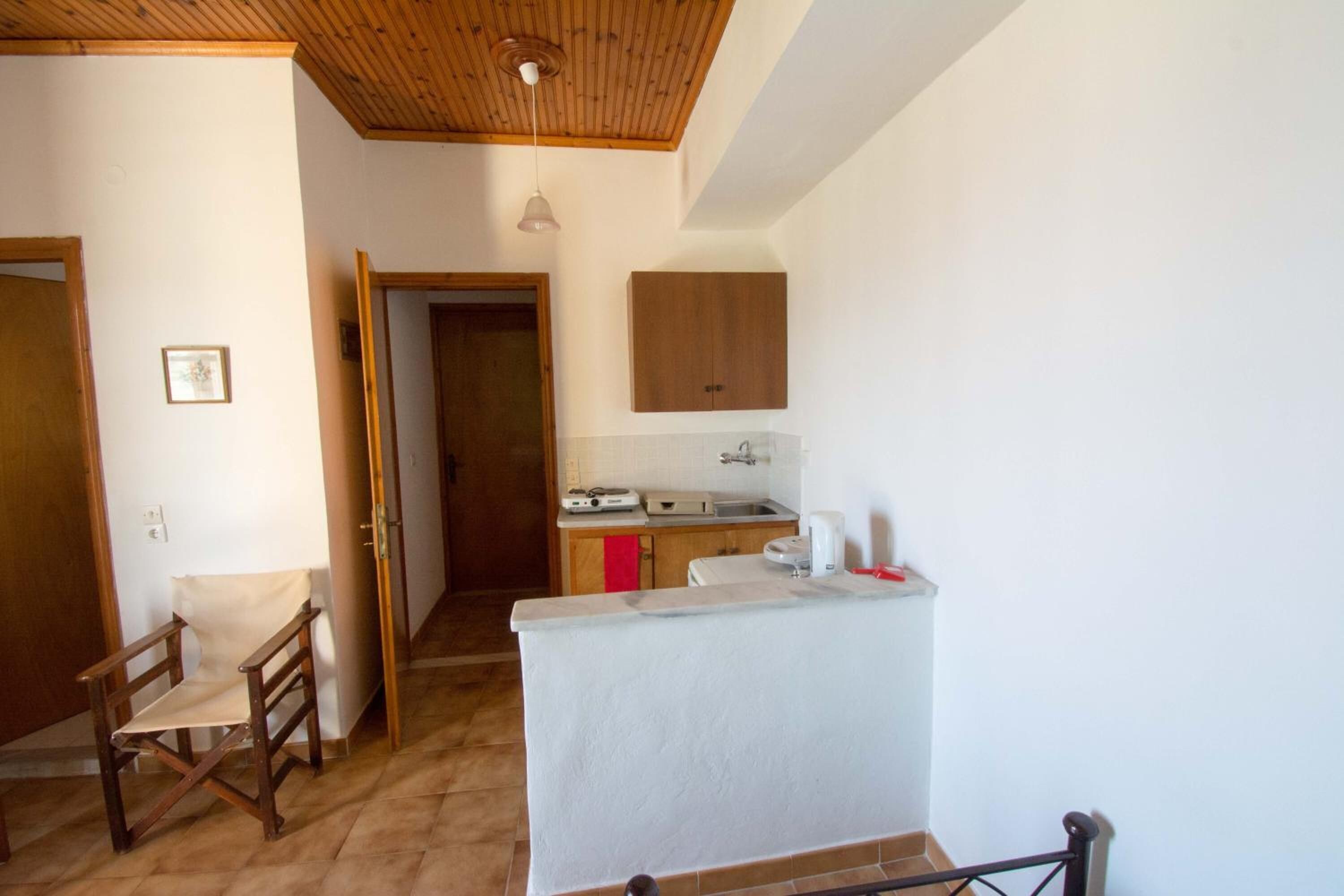 A compact kitchen with wooden cabinets, a countertop, and a small sink.