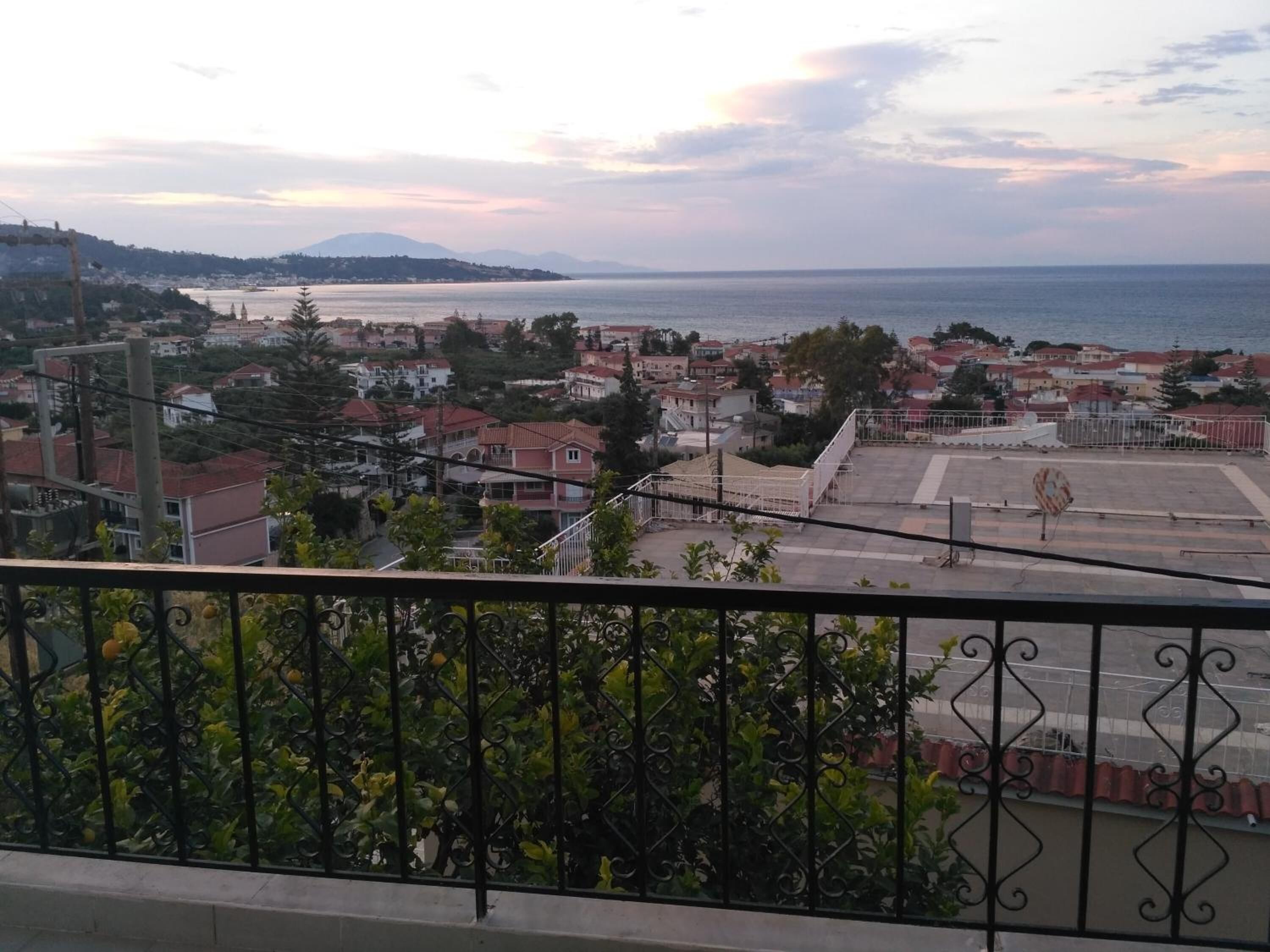 Un pueblo costero con vista al mar y montañas a lo lejos.