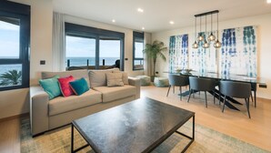 Una sala moderna con un sofá, una mesa de centro y un comedor con sillas y una mesa.