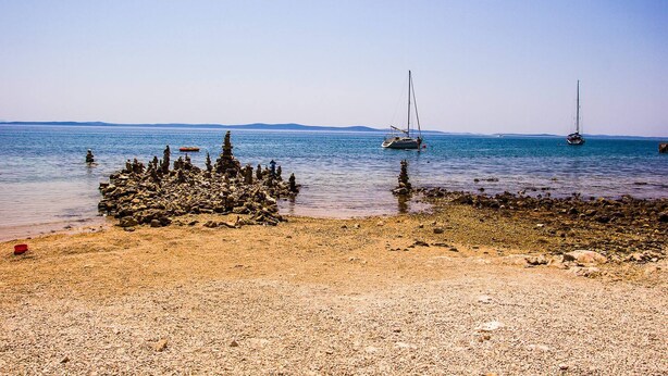 A rocky beach with boats in the water. - DreamDay apartment (Vir)