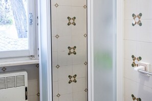 A bathroom with patterned tiles, a window, and a radiator. - M224 - Marcelli, three-room apartment with garden 150m from the sea (Marcelli)