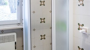 A bathroom with patterned tiles, a window, and a radiator. - M224 - Marcelli, three-room apartment with garden 150m from the sea (Marcelli)