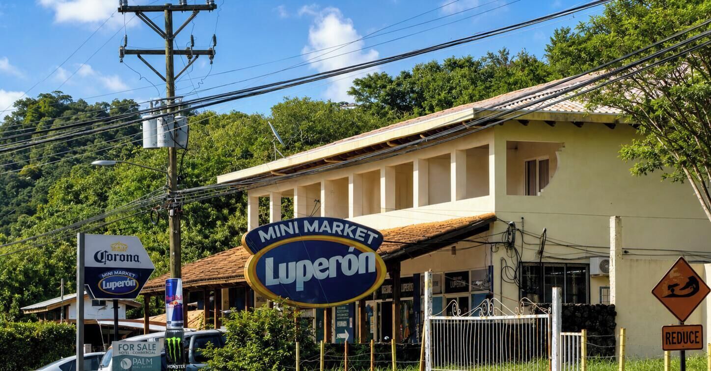 Un bâtiment avec une enseigne indiquant « MINI MARCHÉ Luperon » et une autre pour la bière Corona.