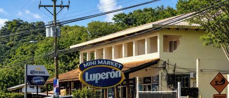 Un bâtiment avec une enseigne indiquant « MINI MARCHÉ Luperon » et une autre pour la bière Corona.