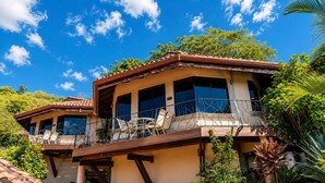 A two-story house with a balcony, large windows, and a view of the sky. - Your Comfortable, Safe, Updated Villa Retreat for 2 to 6 Guests in Playa Hermosa (Playa Hermosa)
