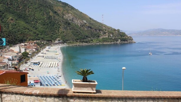 A coastal view with a beach, a mountain, and a clear sky. - Sea Side Rooms (Scilla)