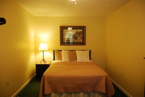 Cozy retreat with a neatly made bed, framed picture, and warm-toned walls.