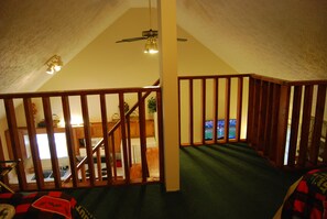 Enjoy a spacious room with a high ceiling, ceiling fan, and a view of the kitchen area.