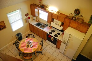 Enjoy cooking and dining in this kitchen with an oven, refrigerator, and dining table for four.
