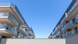 Een modern woongebouw met meerdere verdiepingen, balkons en grote ramen.