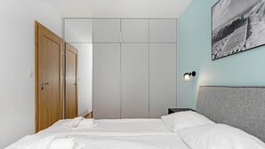 Een hotelkamer met een bed, een kledingkast en een wandlamp.