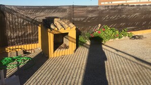 A rooftop terrace with a yellow structure, a green hose, and a flower bed. - "Chalet with Pool" (Montellano)
