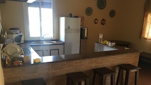 A kitchen with a central island, bar stools, a refrigerator, and a sink. - "Chalet with Pool" (Montellano)