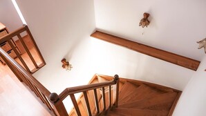 Eine Holztreppe mit Handlauf, einer Wandleuchte und einem Holzboden.