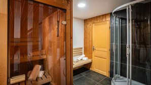 A wooden sauna with benches and a bench with towels.