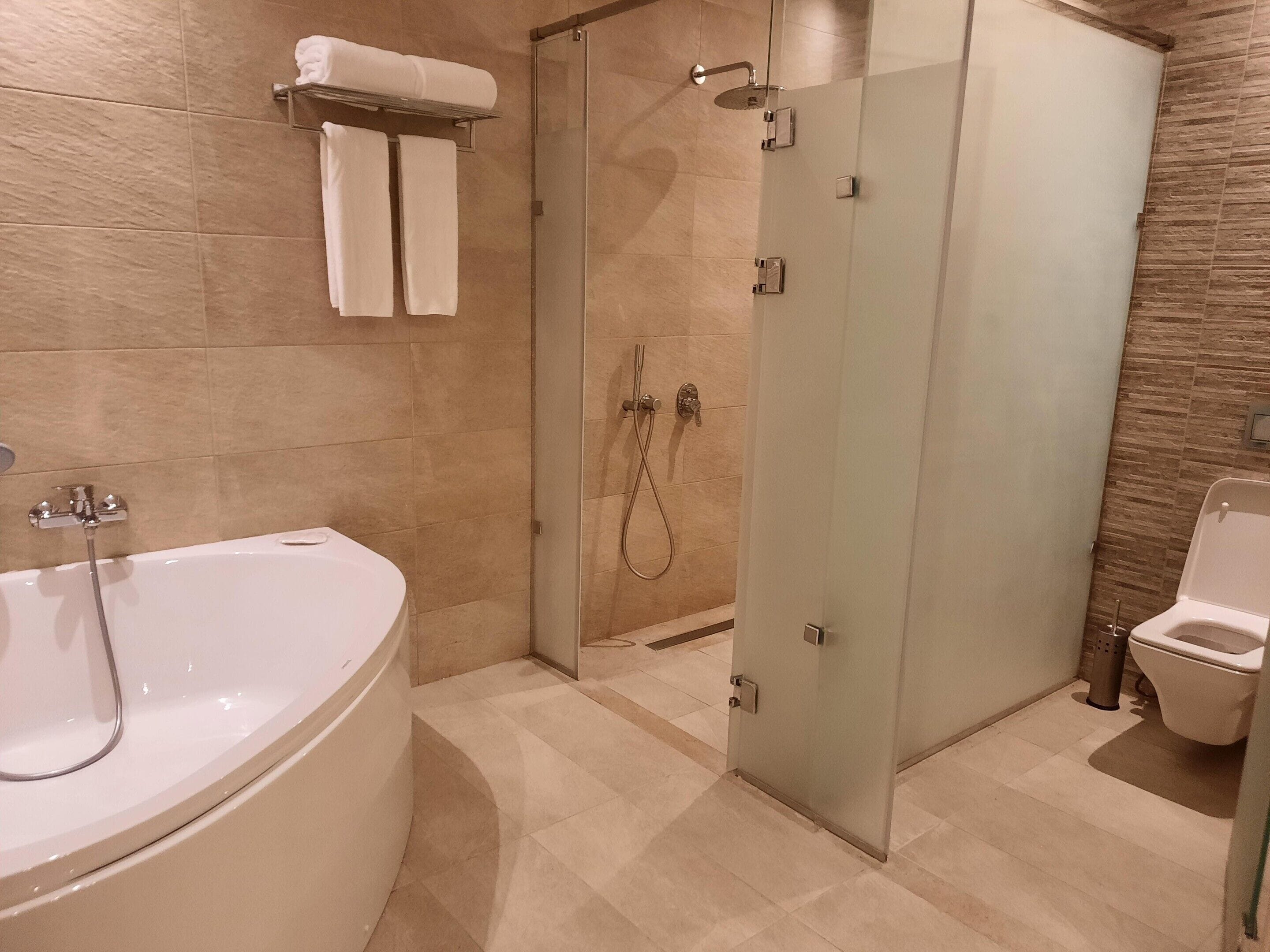 A modern bathroom with a freestanding bathtub, a glass-enclosed shower, and a toilet.