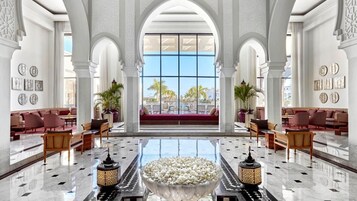 A spacious lobby with high ceilings, large windows, and a central seating area.