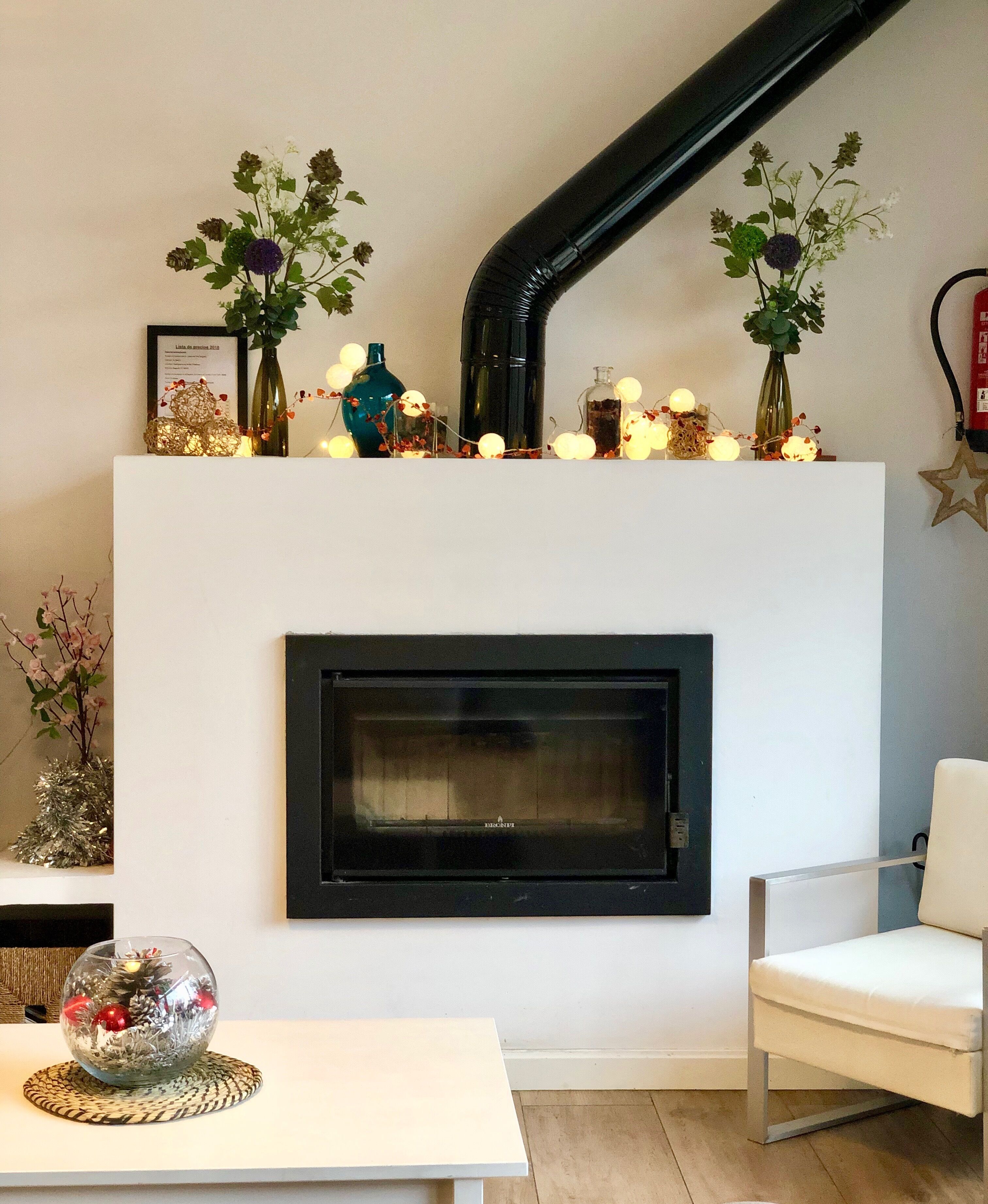 Una sala de estar moderna con chimenea, una mesa blanca y una silla blanca.