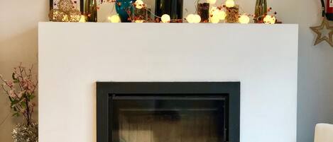 Una sala de estar moderna con chimenea, una mesa blanca y una silla blanca.